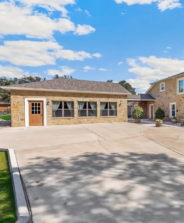 Garage conversion ADU in Los Angeles transformed into a finished living space with stone exterior and large driveway